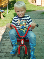 Junge beim beim Dreirad-Roller fahren
