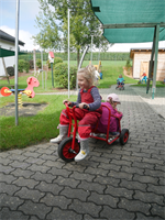 mehrere Kinder beim Dreirad-Roller fahren