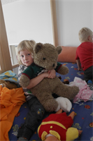 Kind beim Kuscheln mit Teddibär