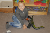 Junge beim spielen mit Dinosaurier